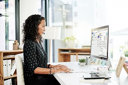 Lady sitting at a desk and working on a computer | Government document management software